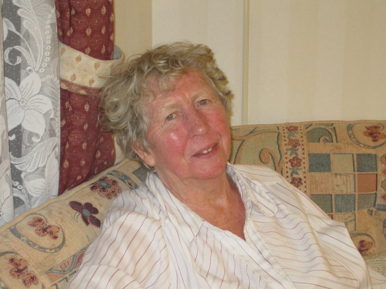 Ruth O'Callaghan, seated on a patterned sofa